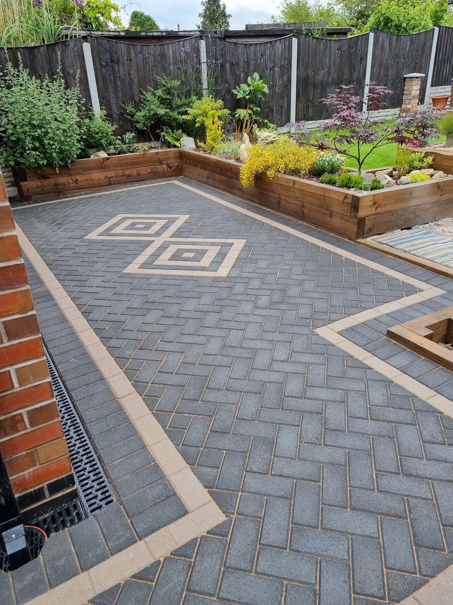 Charcoal block paving with buff diamond feature detail and channel drainage