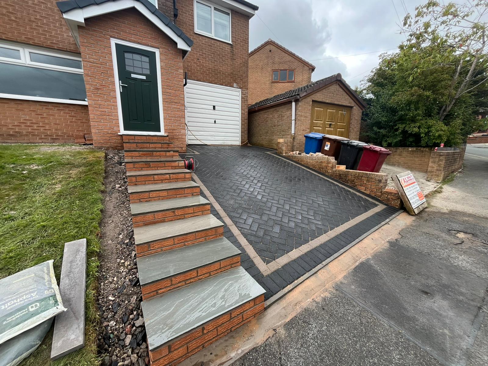 New brick and flag steps beside a block paved driveway on a sloping Lancashire plot