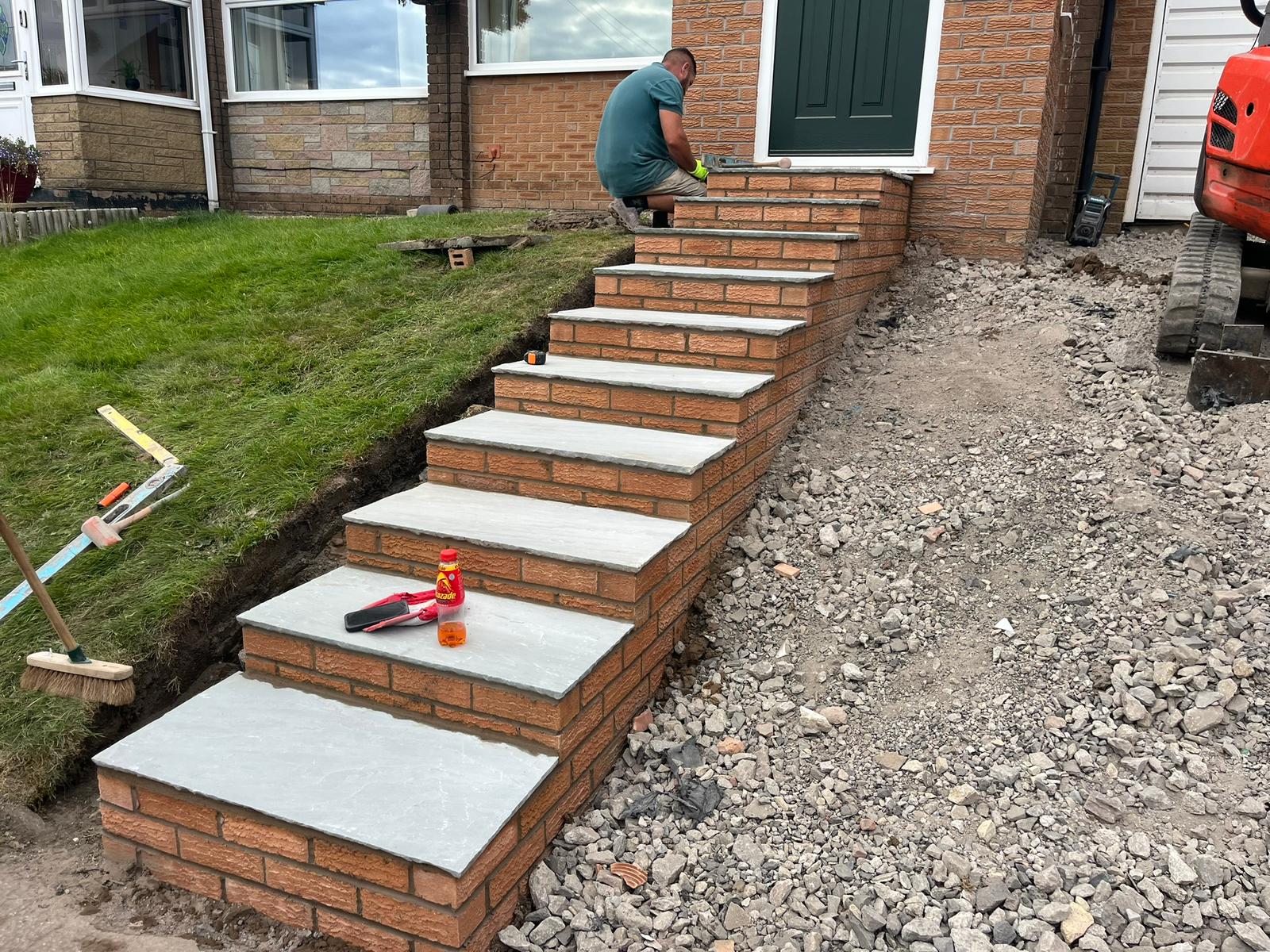 Brick and flag steps part built, with the sub-base stone visible alongside